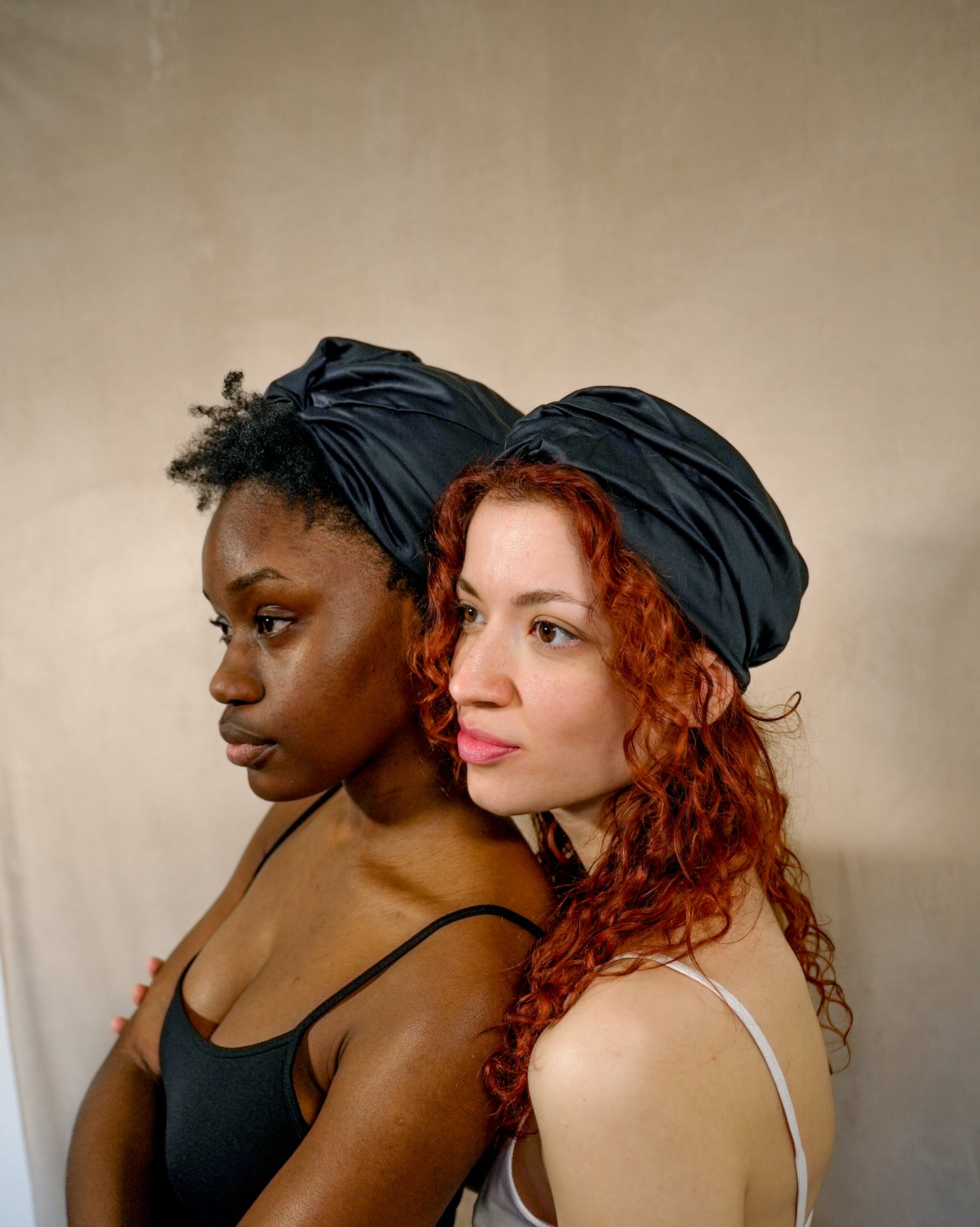 Two models in BetterBe bamboo bonnets, warm studio scene highlighting comfortable fit
