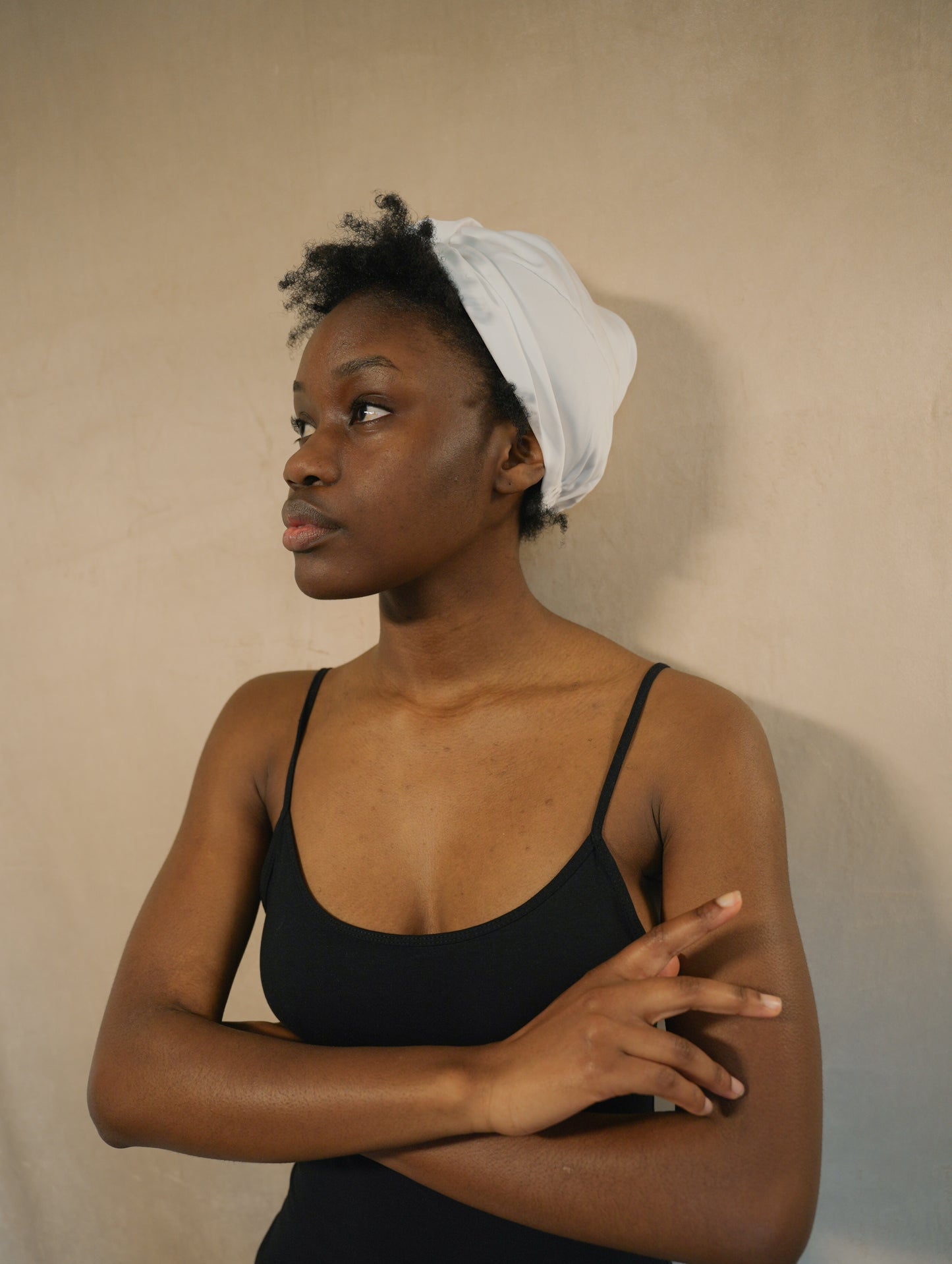 Model wearing BetterBe bamboo sleep bonnet, studio side pose showing comfortable fit