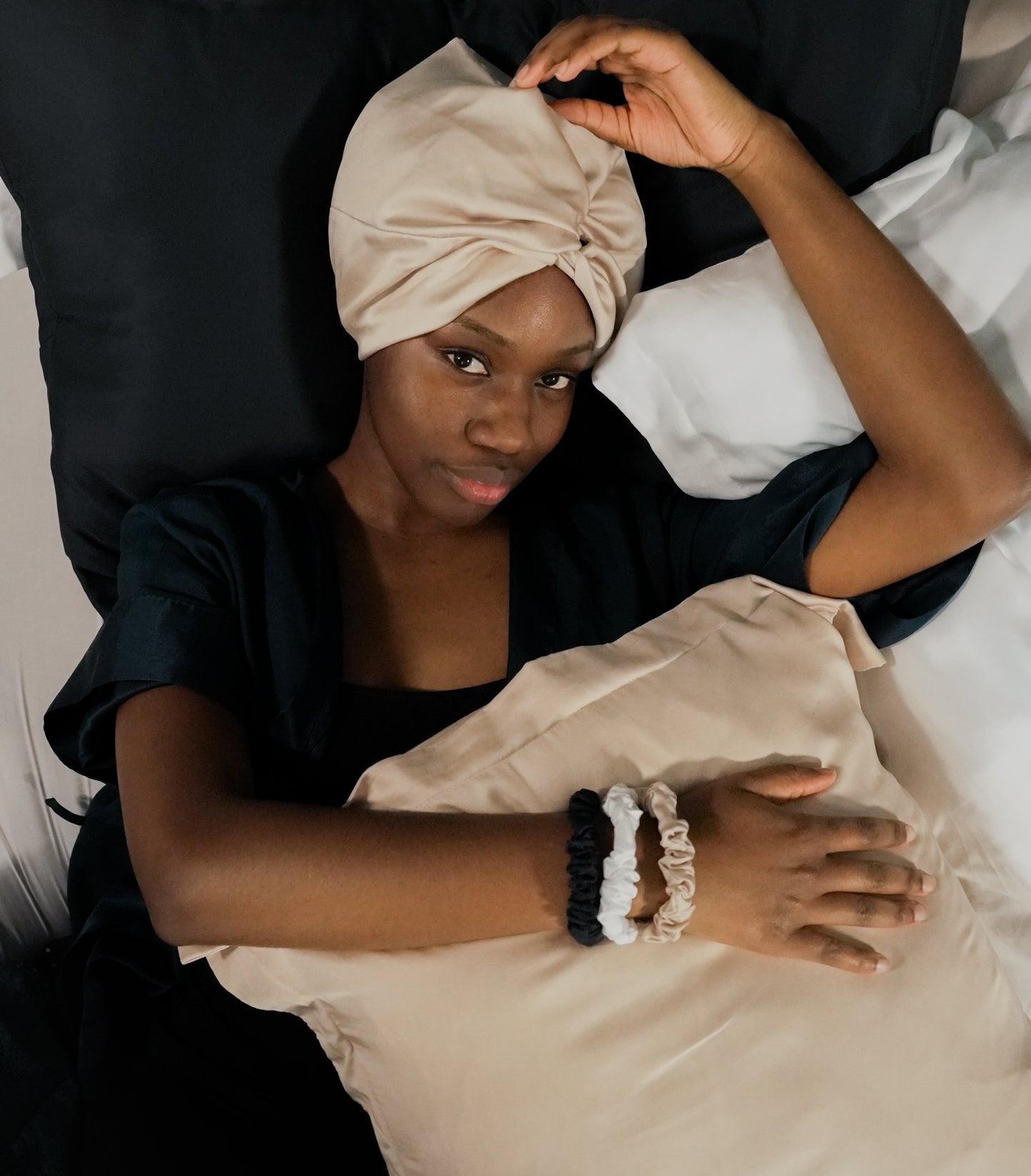 Woman relaxing with BetterBe bamboo sleep bonnets, cozy night routine that protects hair