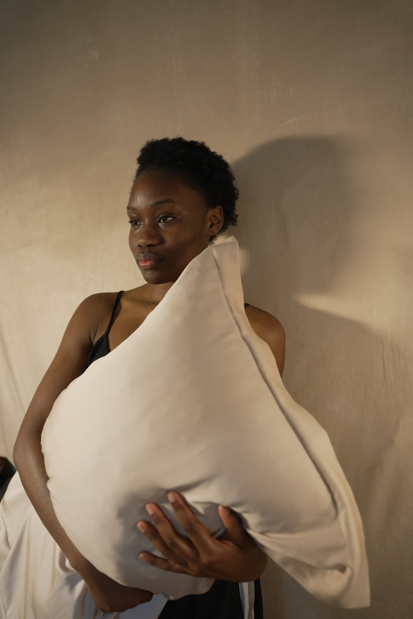 Model with BetterBe bamboo pillowcase against back, nightly routine for smooth frizz reduced hair