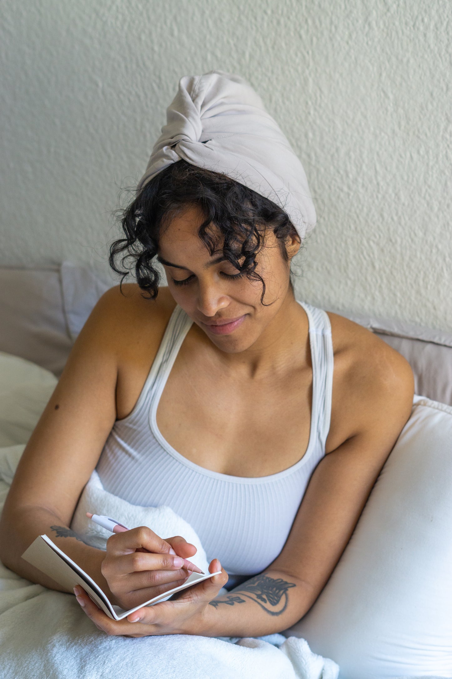 BetterBe bamboo sleep bonnet on model at night, breathable fit that protects curls from frizz