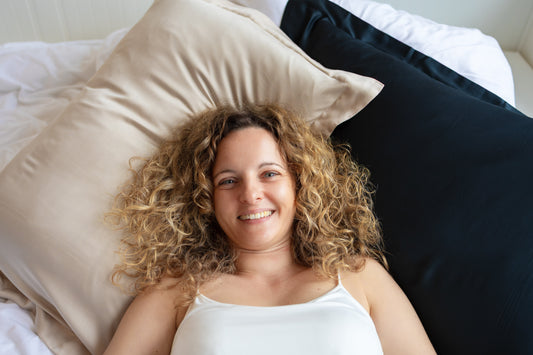 Woman with curly hair resting on a BetterBe vegan bamboo pillowcase