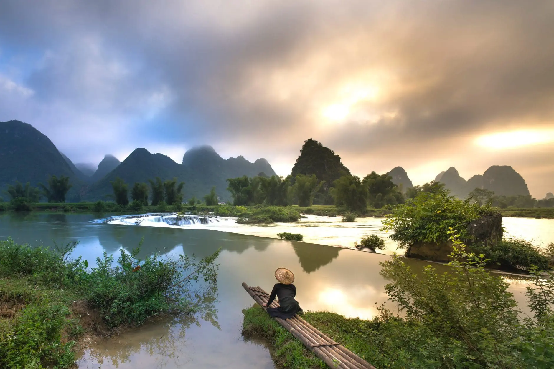 beautiful view with man sitting on bamboo raft