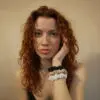 Woman with curls wearing 3 slim 100% bamboo scrunchies around her wrist