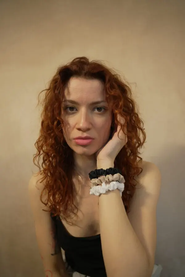 DSC00927 Woman with curls wearing 3 slim 100% bamboo scrunchies around her wrist