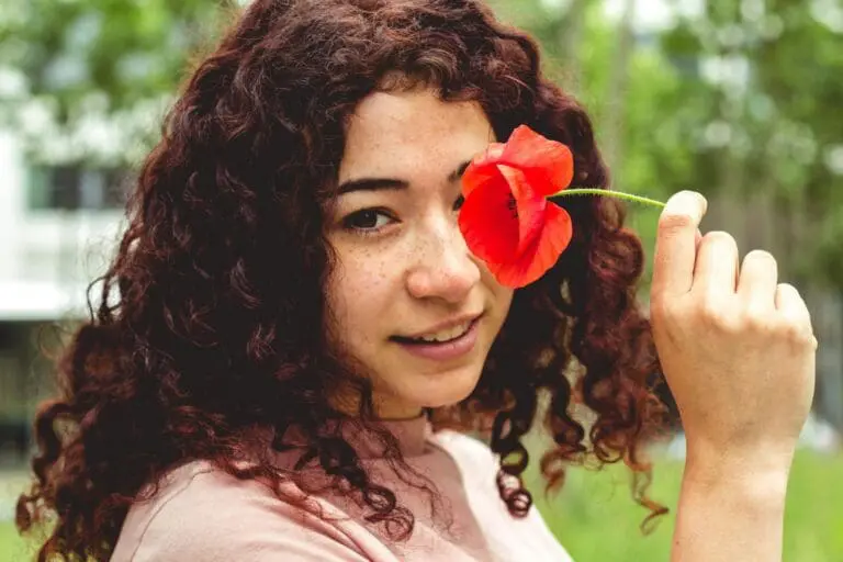 curly girl with poppy flower